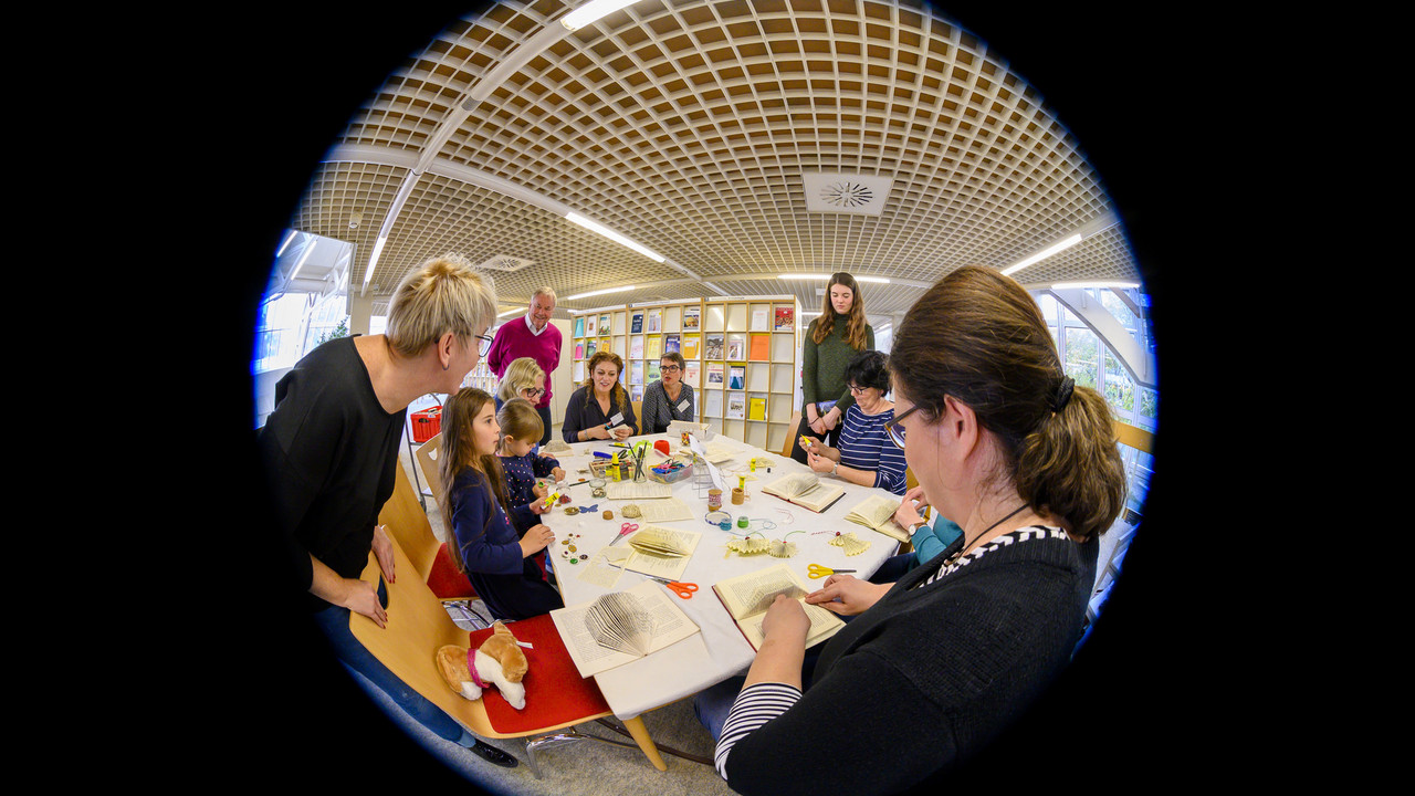 Personen basteln Skulpturen aus Büchern