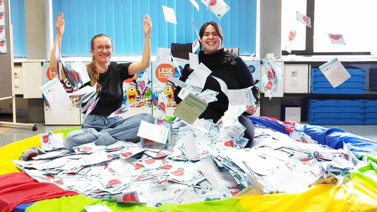 Zwei junge Frauen vor einem bunten Becken mit Loskarten