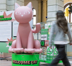 Große Katze aus Kunststoff an der eine Frau vorbeigeht