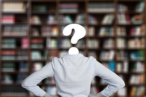 Bücherwand davor eine Person mit Fragezeichen als Kopf