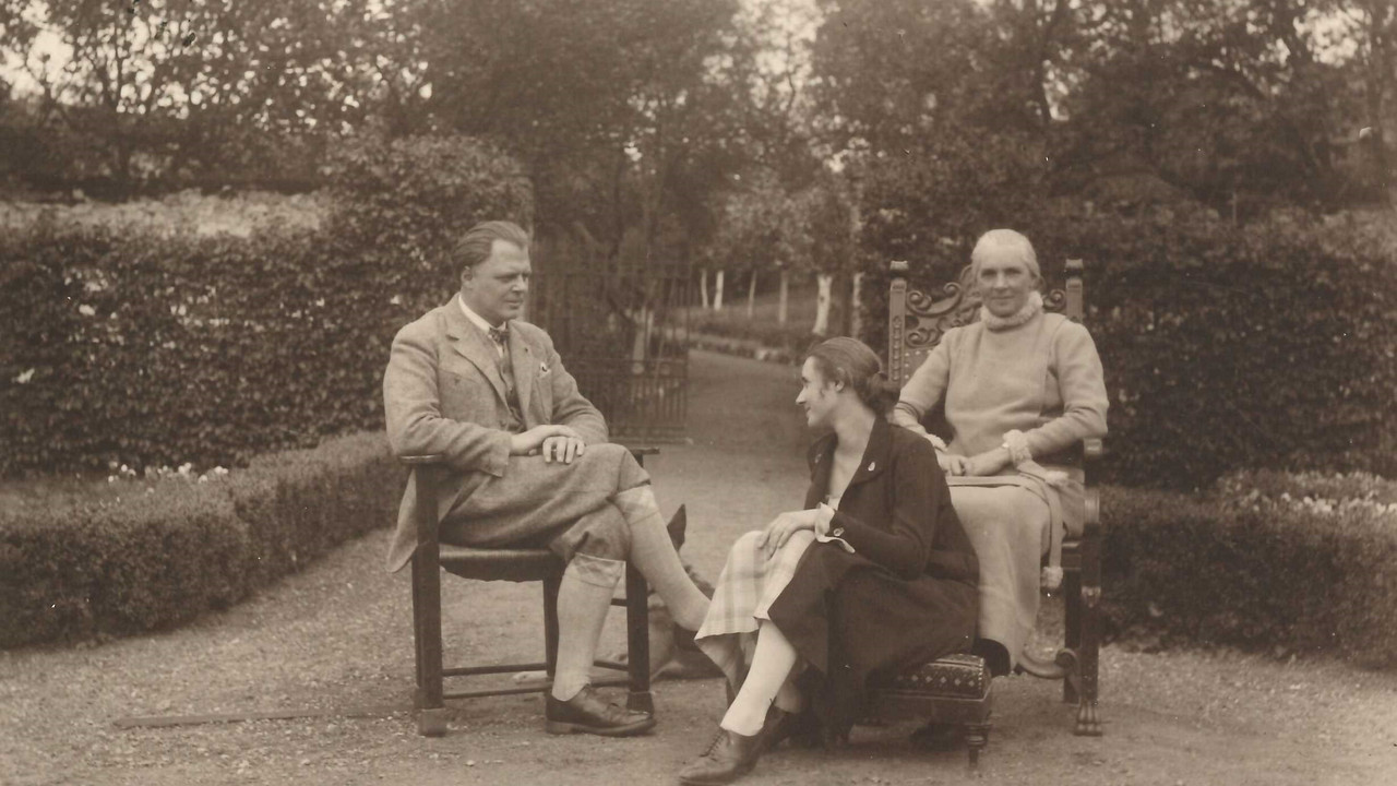 Schwarzweiß Foto von drei Personen, die auf Stühlen in einer Grünanlage sitzen: Fritz von Unruh, Mathild, Mutter Mathilde von Unruh