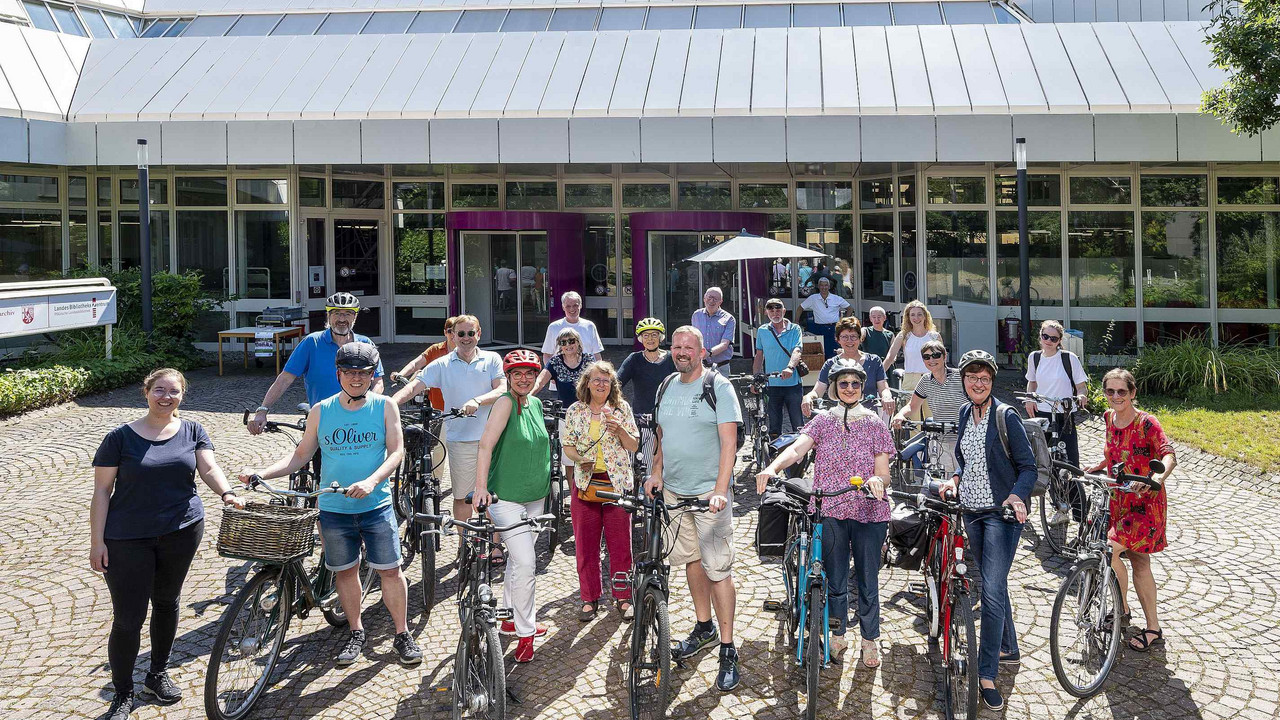Menschen mit Fahrrädern vor dem Gebäude der Pfälzischen Landesbibliothek