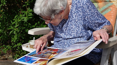 Ältere Frau über ein Bilderbuch gebeugt