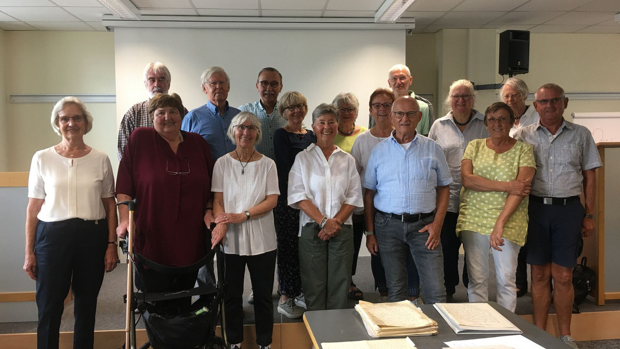Personengruppe, im Vordergrund Schriftstücke