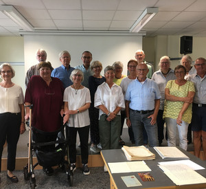 Personengruppe, im Vordergrund Schriftstücke